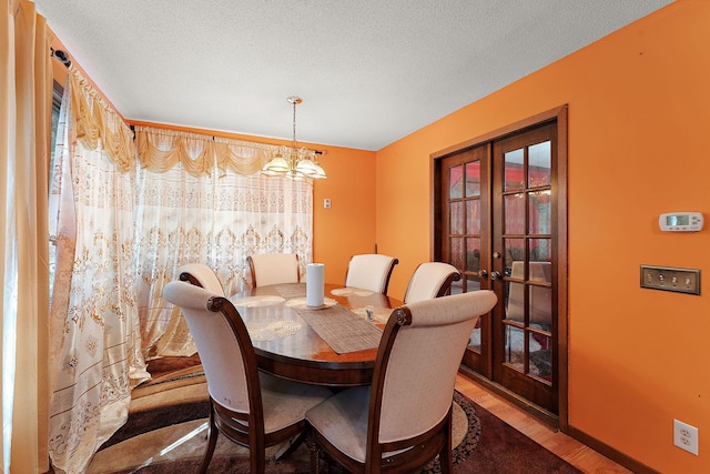 7609 James Ave N, Brooklyn Park, MN 55444 - dining space with french doors, plenty of natural light, wood finished floors, and a chandelier