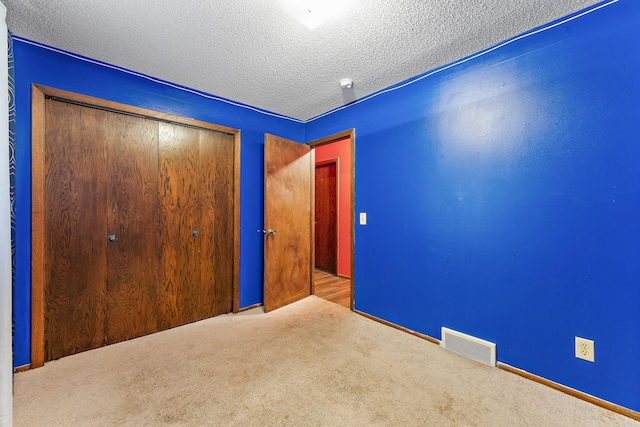 7609 James Ave N, Brooklyn Park, MN 55444 - unfurnished bedroom with carpet flooring, a closet, and a textured ceiling