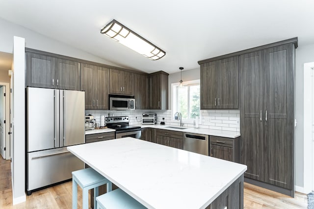 2 Lillie Ln SE, Pine Island, MN 55963 - kitchen featuring appliances with stainless steel finishes, vaulted ceiling, dark brown cabinetry, decorative backsplash, and light countertops