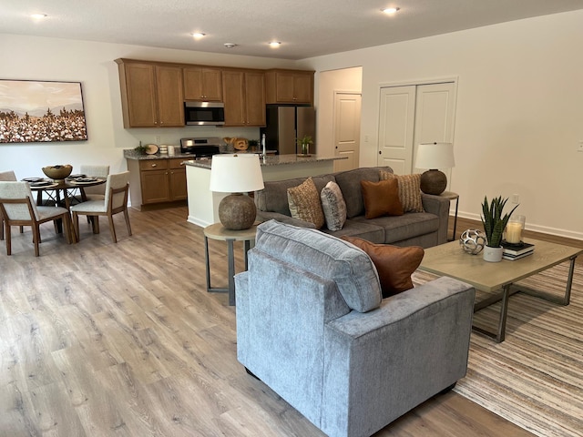 living area with light wood finished floors and recessed lighting