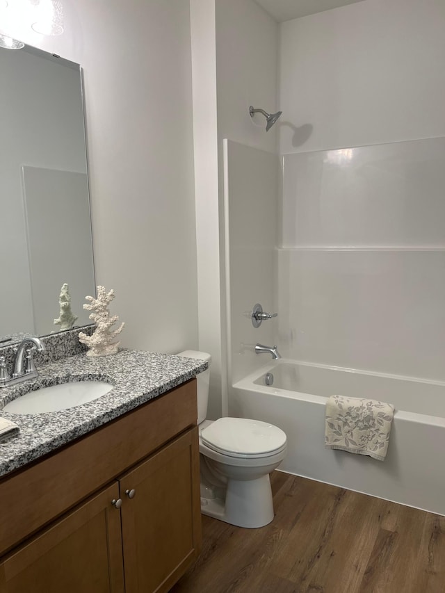 full bathroom with wood finished floors, vanity, and shower / tub combination