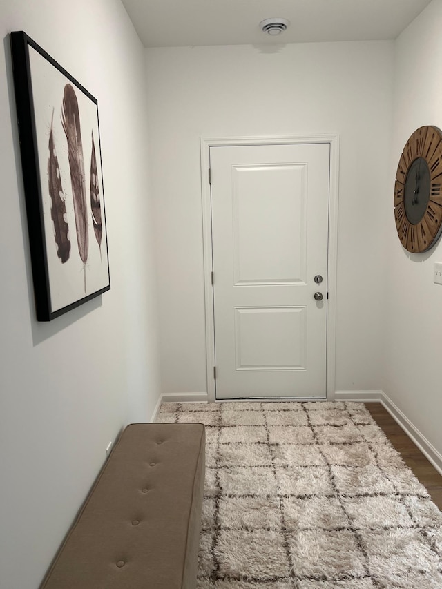 doorway to outside with baseboards and wood finished floors
