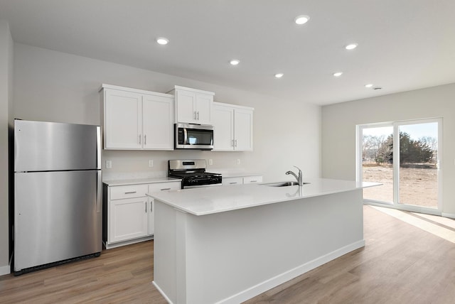 39730 Fallbrook Ave, North Branch, MN 55056 - kitchen with stainless steel appliances, light wood-style floors, white cabinets, recessed lighting, and a center island with sink