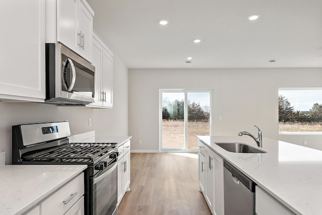 39730 Fallbrook Ave, North Branch, MN 55056 - kitchen featuring appliances with stainless steel finishes, light wood-style floors, white cabinets, light stone counters, and recessed lighting