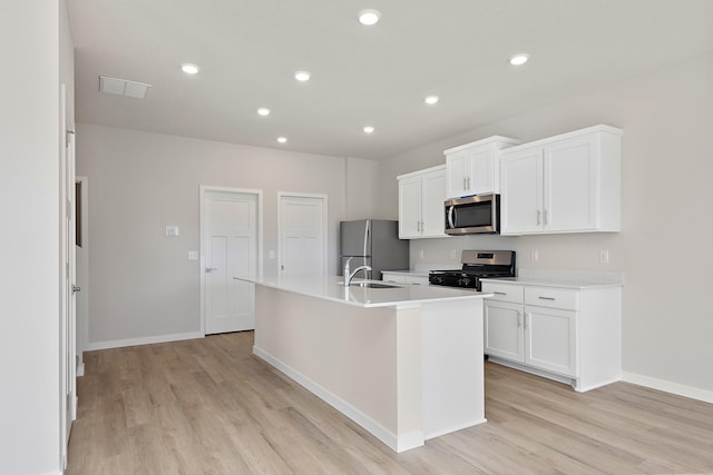 39730 Fallbrook Ave, North Branch, MN 55056 - kitchen with stainless steel appliances, light wood-type flooring, an island with sink, white cabinets, and recessed lighting