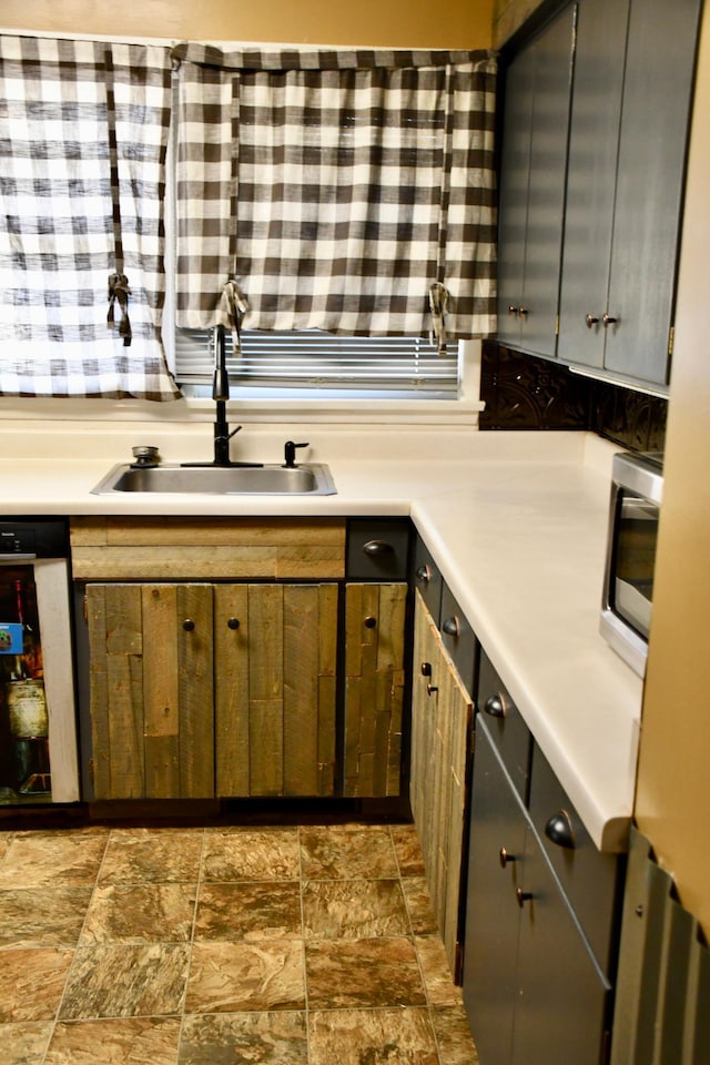 308 Maple Ave S, Thief River Falls, MN 56701 - kitchen with dark stone finish floors, light countertops, stainless steel microwave, dishwashing machine, and gray cabinets