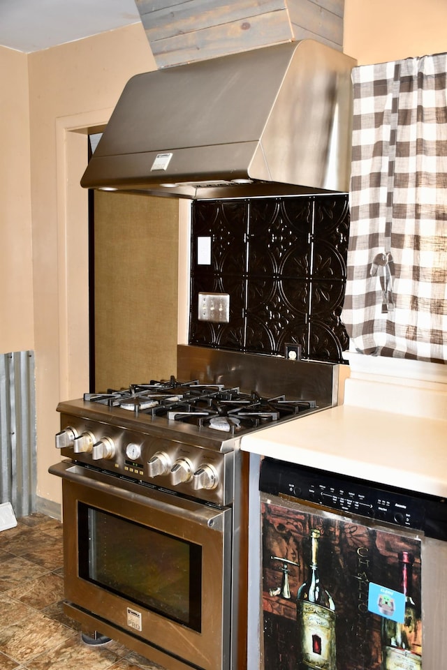 308 Maple Ave S, Thief River Falls, MN 56701 - kitchen with stainless steel gas range, wall chimney range hood, and stone finish floors