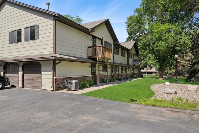 13525 Zenith Ln, Eden Prairie, MN 55346 - view of property exterior with a garage, a balcony, brick siding, a lawn, and asphalt driveway