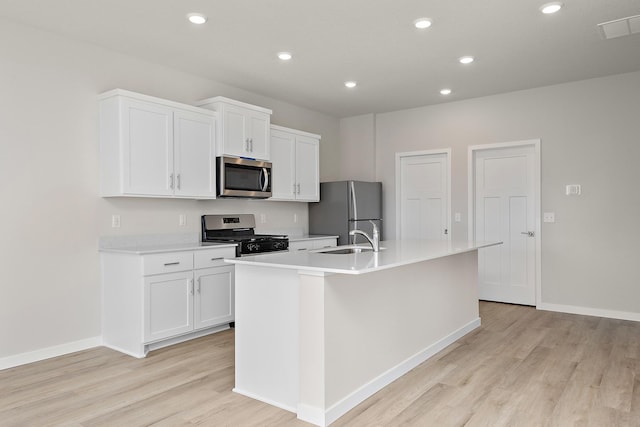 39729 Fallbrook Ave, North Branch, MN 55056 - kitchen with stainless steel appliances, a kitchen island with sink, light wood-style flooring, white cabinetry, and recessed lighting
