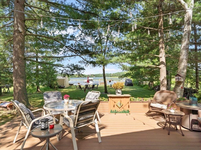 26803 Pelican Beach Rd, Merrifield, MN 56465 - wooden terrace featuring outdoor dining area, a lawn, and a water view