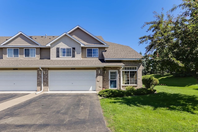 16424 Elm Creek Ln Unit 4029, Lakeville, MN 55044 - view of front of house featuring driveway, brick siding, a front lawn, a garage, and roof with shingles