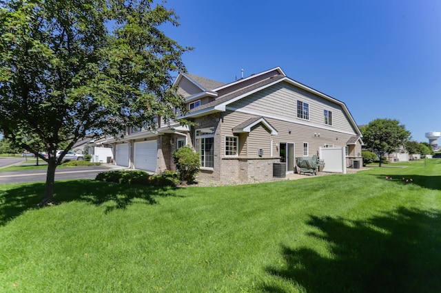 16424 Elm Creek Ln Unit 4029, Lakeville, MN 55044 - back of property featuring a yard, driveway, brick siding, and an attached garage