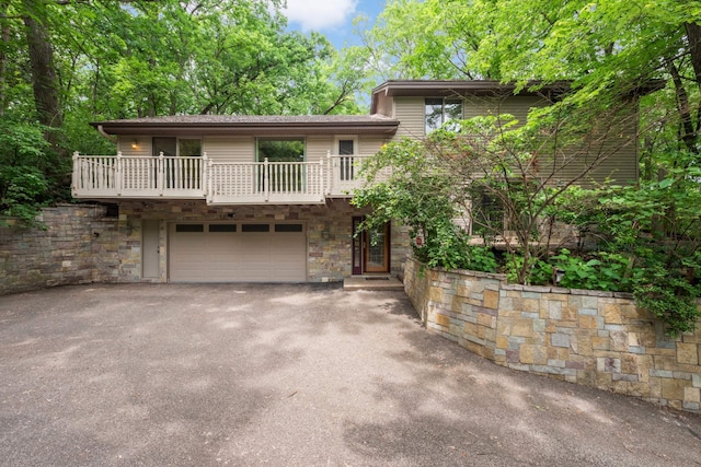 8040 Lea Rd, Bloomington, MN 55438 - view of front facade featuring a balcony, stone siding, driveway, and a garage