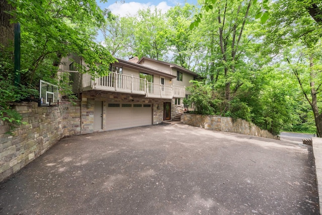 8040 Lea Rd, Bloomington, MN 55438 - view of front of property with stone siding, asphalt driveway, and a garage