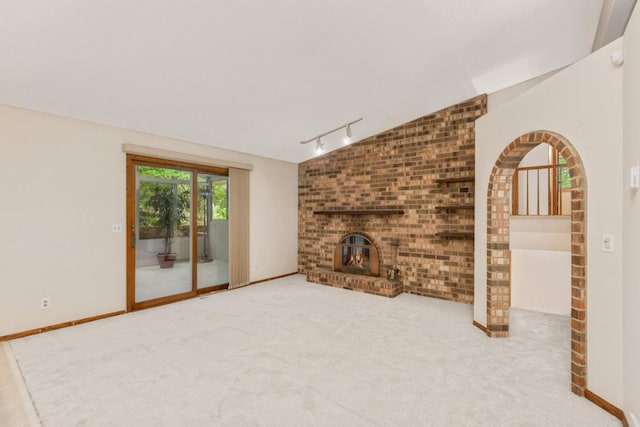 8040 Lea Rd, Bloomington, MN 55438 - unfurnished living room featuring rail lighting, carpet, a fireplace, and brick wall