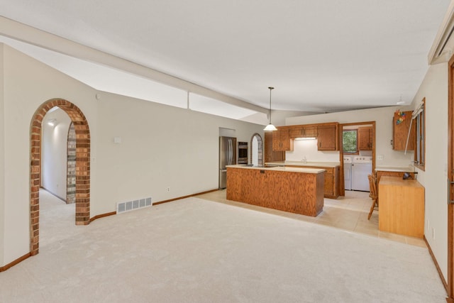 8040 Lea Rd, Bloomington, MN 55438 - kitchen with arched walkways, washer / clothes dryer, lofted ceiling, light countertops, and brown cabinetry