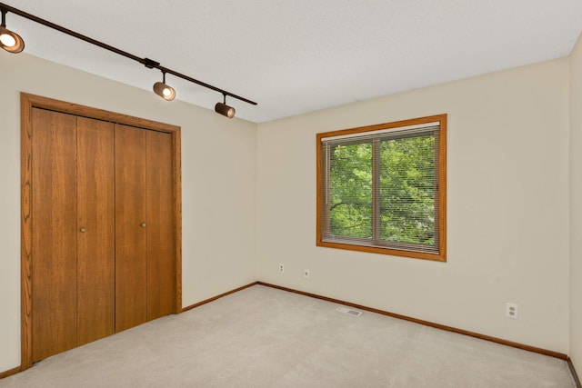 8040 Lea Rd, Bloomington, MN 55438 - unfurnished bedroom with light colored carpet, a closet, and rail lighting