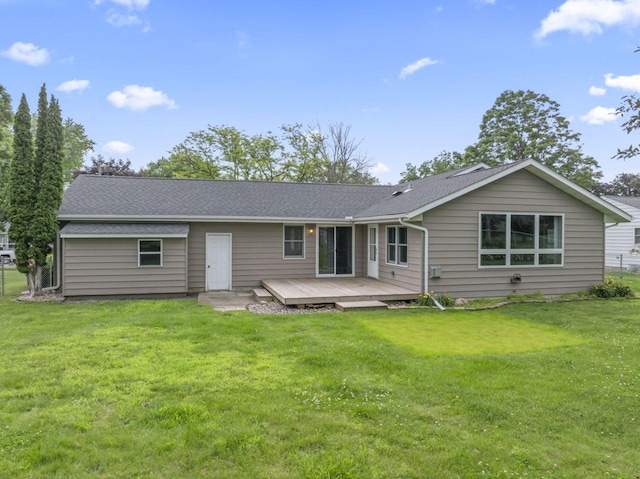 2100 10th St SW, Austin, MN 55912 - rear view of property featuring a deck, a lawn, and a shingled roof