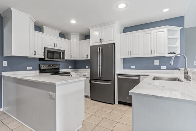 2100 10th St SW, Austin, MN 55912 - kitchen with appliances with stainless steel finishes, a peninsula, open shelves, light tile patterned floors, and white cabinets