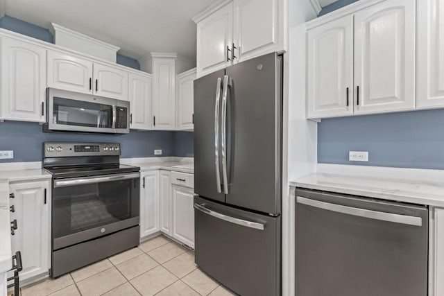 2100 10th St SW, Austin, MN 55912 - kitchen with appliances with stainless steel finishes, white cabinetry, light tile patterned flooring, and light stone countertops