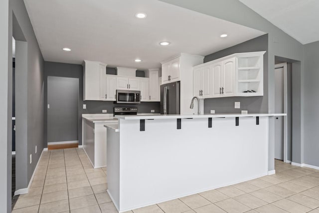 2100 10th St SW, Austin, MN 55912 - kitchen featuring appliances with stainless steel finishes, white cabinets, a breakfast bar area, open shelves, and recessed lighting