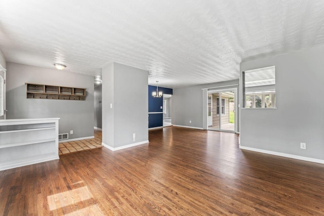 2100 10th St SW, Austin, MN 55912 - unfurnished living room with wood finished floors and a chandelier
