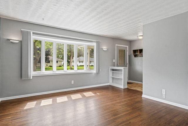 2100 10th St SW, Austin, MN 55912 - unfurnished living room featuring wood finished floors and baseboards
