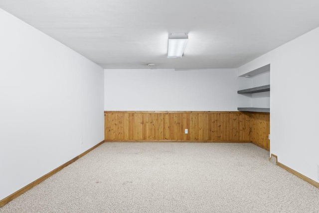 2100 10th St SW, Austin, MN 55912 - spare room featuring light carpet and wooden walls