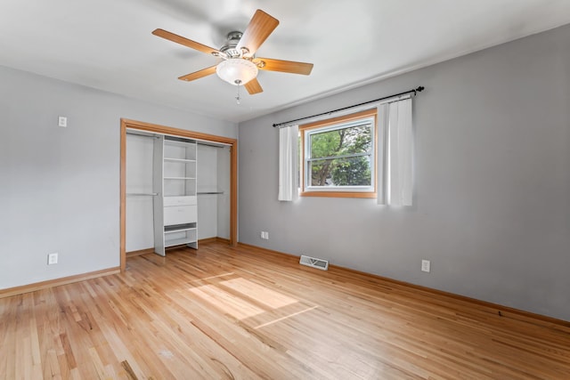 2100 10th St SW, Austin, MN 55912 - unfurnished bedroom with light wood finished floors, a closet, and a ceiling fan