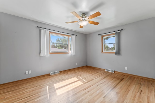 2100 10th St SW, Austin, MN 55912 - unfurnished room with healthy amount of natural light, wood finished floors, and a ceiling fan
