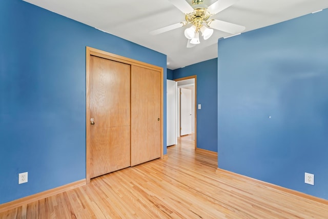 2100 10th St SW, Austin, MN 55912 - unfurnished bedroom featuring wood finished floors, a closet, and a ceiling fan