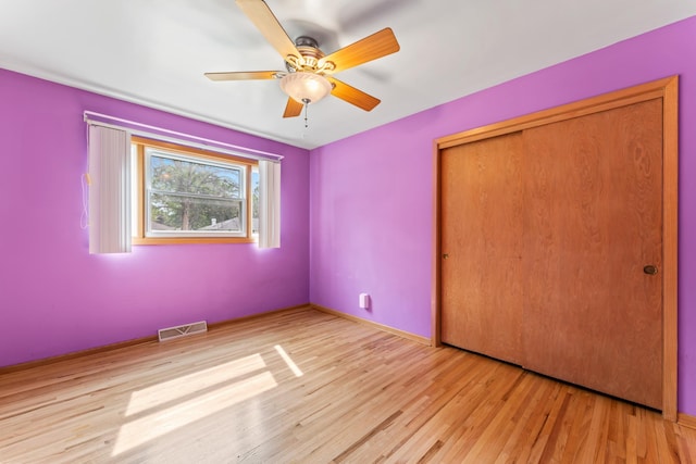 2100 10th St SW, Austin, MN 55912 - unfurnished bedroom with wood finished floors, a closet, and ceiling fan