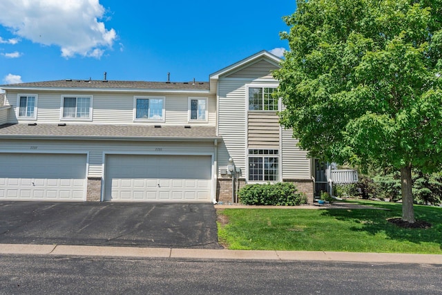 7735 Lachman Ave NE, Otsego, MN 55301 - townhome / multi-family property featuring brick siding, asphalt driveway, a front yard, and a garage