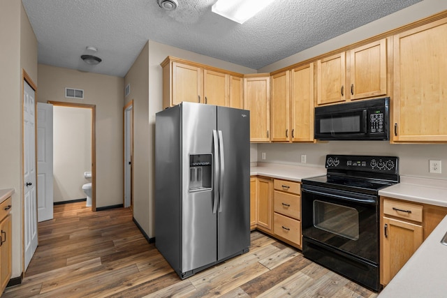 7735 Lachman Ave NE, Otsego, MN 55301 - kitchen featuring black appliances, light brown cabinetry, light countertops, wood finished floors, and a textured ceiling
