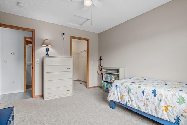 940 14th Ln SE, Cambridge, MN 55008 - bedroom with light carpet, a spacious closet, attic access, and ceiling fan