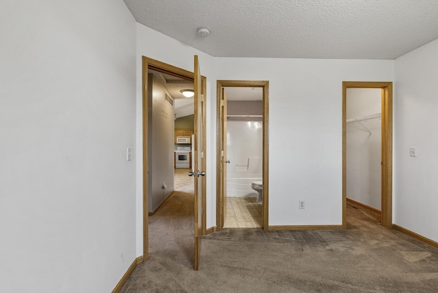 30354 118th St, Baldwin Twp, MN 55371 - unfurnished bedroom featuring carpet flooring, a walk in closet, a closet, connected bathroom, and a textured ceiling