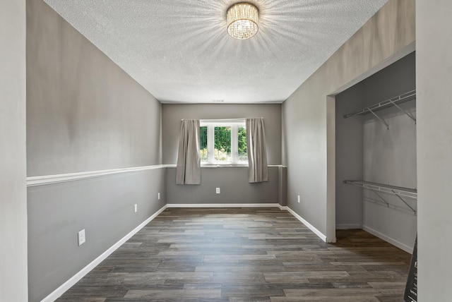 30354 118th St, Baldwin Twp, MN 55371 - unfurnished bedroom featuring a textured ceiling, dark wood-style flooring, and a chandelier