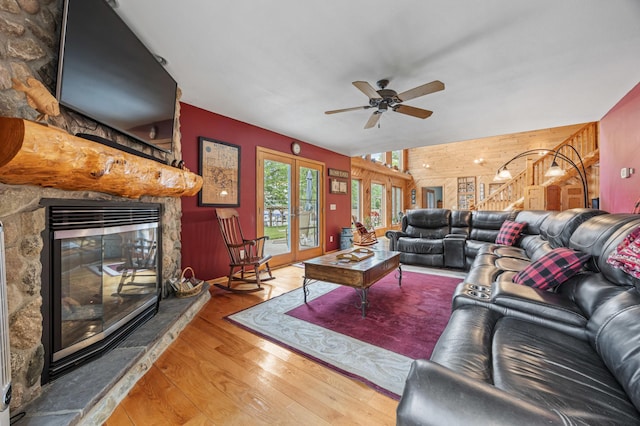 36773 Rose Lake Rd, Hobart Twp, MN 56544 - living area featuring a stone fireplace, wooden walls, wood finished floors, and a ceiling fan