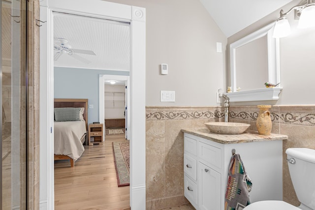 3599 210th St E, Vermillion Twp, MN 55024 - ensuite bathroom featuring tile walls, wood finished floors, a wainscoted wall, ceiling fan, and vanity