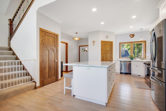 18465 Lake Ln, Chengwatana Twp, MN 55063 - kitchen with appliances with stainless steel finishes, a kitchen island, light wood-style flooring, white cabinetry, and recessed lighting