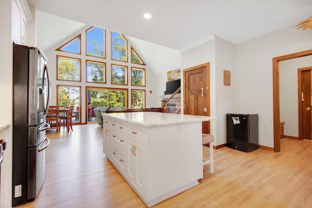 18465 Lake Ln, Chengwatana Twp, MN 55063 - kitchen featuring stainless steel fridge, white cabinetry, light wood-style floors, a breakfast bar, and recessed lighting