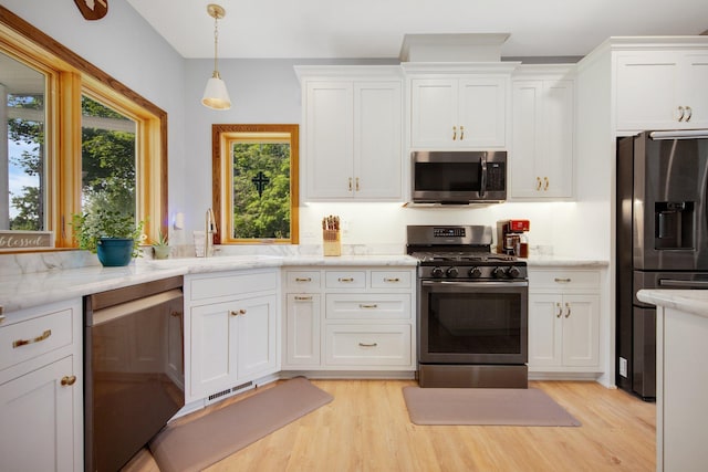 18465 Lake Ln, Chengwatana Twp, MN 55063 - kitchen featuring appliances with stainless steel finishes, white cabinets, light wood finished floors, and pendant lighting