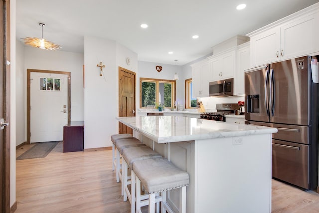 18465 Lake Ln, Chengwatana Twp, MN 55063 - kitchen with stainless steel appliances, light wood-style flooring, white cabinetry, a breakfast bar, and recessed lighting