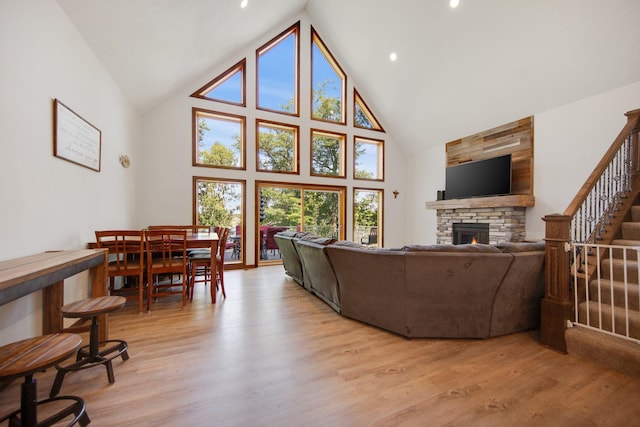 18465 Lake Ln, Chengwatana Twp, MN 55063 - living room featuring high vaulted ceiling, a fireplace, light wood-style floors, and stairway