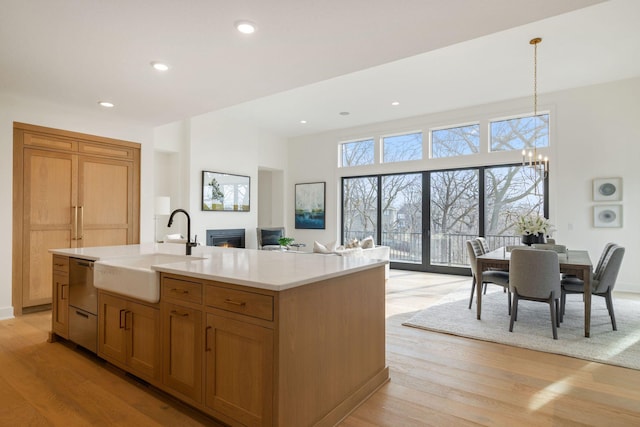 5250 Polaris Ln N, Plymouth, MN 55446 - kitchen featuring dishwasher, a chandelier, light wood-type flooring, light countertops, and a warm lit fireplace