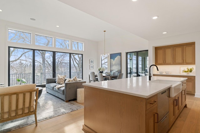 5250 Polaris Ln N, Plymouth, MN 55446 - kitchen featuring light wood-type flooring, stainless steel dishwasher, a kitchen island with sink, light stone counters, and recessed lighting