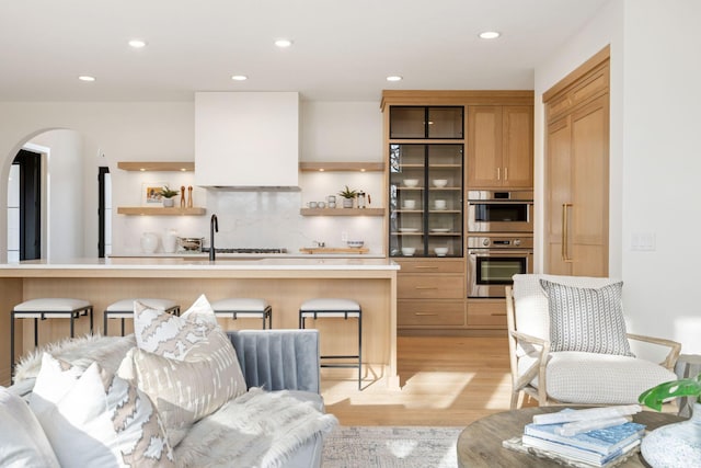 5250 Polaris Ln N, Plymouth, MN 55446 - kitchen with open shelves, stainless steel double oven, arched walkways, a breakfast bar area, and recessed lighting