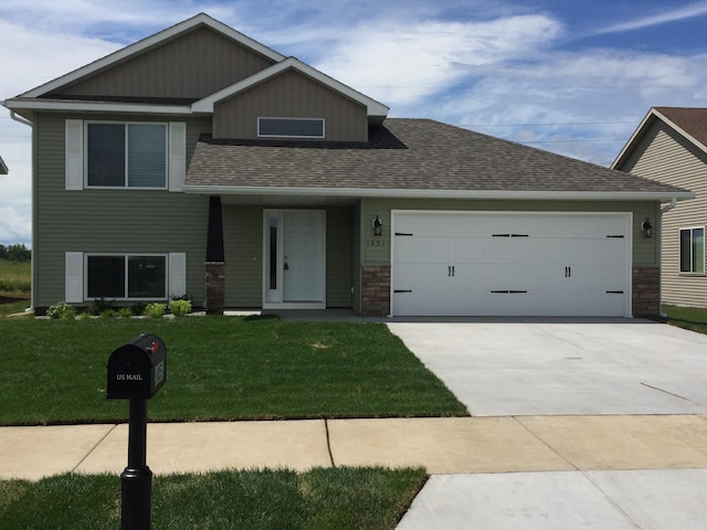 1051 Yellowstone Ave, Saint Cloud, MN 56303 - view of front facade with a garage, a front yard, driveway, a shingled roof, and stone siding