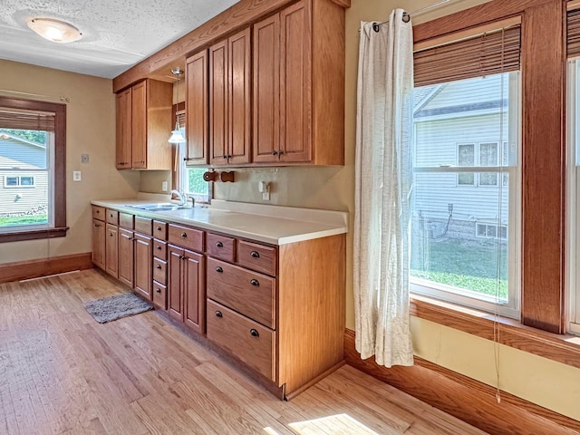 306 Jefferson St, Minneota, MN 56264 - kitchen with brown cabinetry, light countertops, and light wood-style flooring