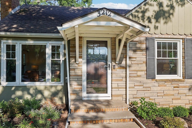 3212 Kentucky Ave S, Saint Louis Park, MN 55426 - property entrance featuring a chimney, a shingled roof, and stone siding